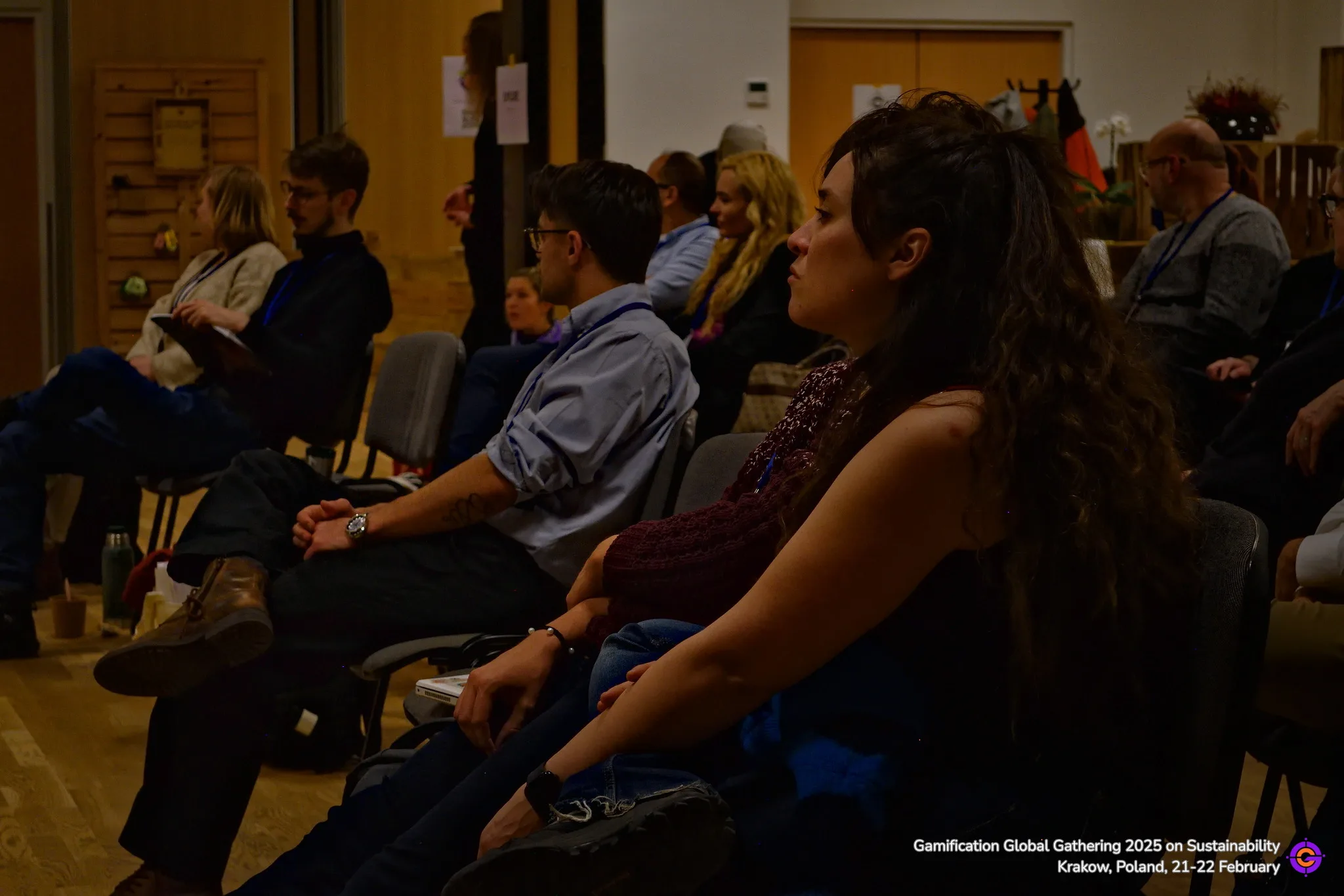 Gamification Global Gathering attendees listening attentively indoors.