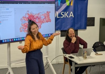 A girl presenting in front of the screen smiling